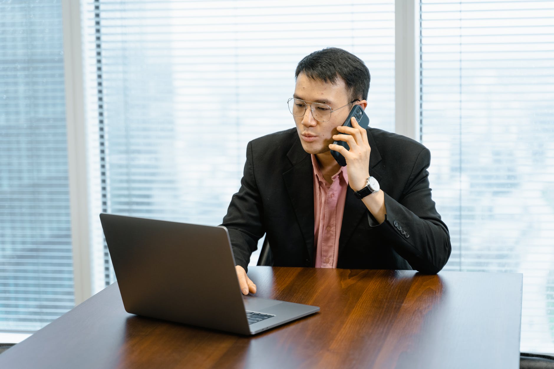 a man having a phone call while using his laptop